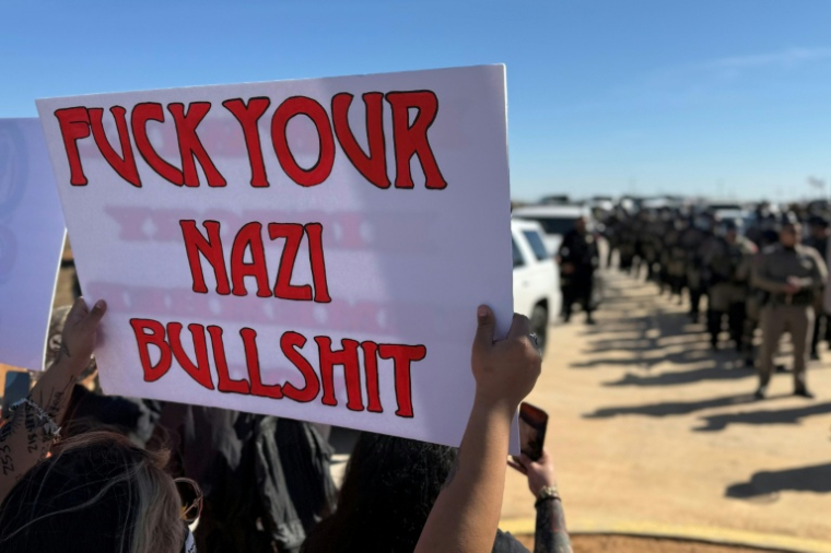 Une personne brandit une pancarte contre l'action de l'ICE, à Dilley aux Etats-Unis, le 28 janvier 2026 ( AFP / Moisés ÁVILA )