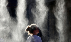 Une femme se rafraîchit sous un brumisateur lors de la Fête de la Musique à Bordeaux, le 21 juin 2026   ( AFP / ROMAIN PERROCHEAU )