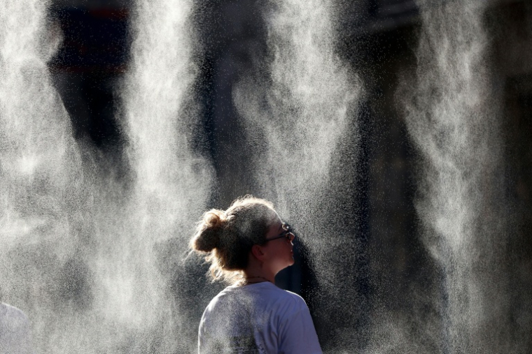 Une femme se rafraîchit sous un brumisateur lors de la Fête de la Musique à Bordeaux, le 21 juin 2026   ( AFP / ROMAIN PERROCHEAU )