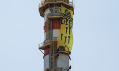 Des militants de Greenpeace affichent une bannière suspendue à une cheminée lors d'une manifestation contre l'entreprise énergétique Naturgy, à Campanillas