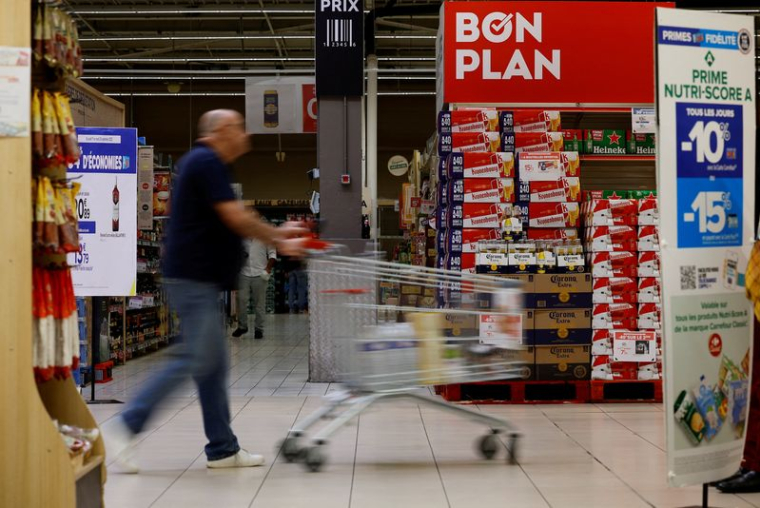 Un client pousse un caddie alors qu'il fait ses courses dans un supermarché Carrefour à Montesson