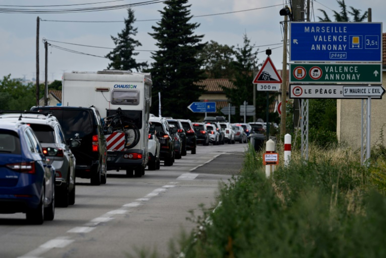 Des automobilistes le long de nationale 7, près de la commune du Péage-de-Roussillon, en Isère, le 2 août 2025 ( AFP / JEAN-PHILIPPE KSIAZEK )