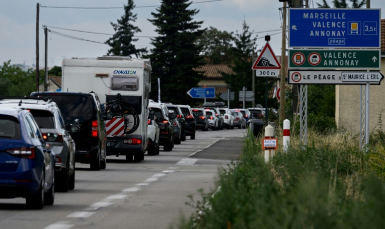 Des automobilistes le long de nationale 7, près de la commune du Péage-de-Roussillon, en Isère, le 2 août 2025  ( AFP / JEAN-PHILIPPE KSIAZEK )