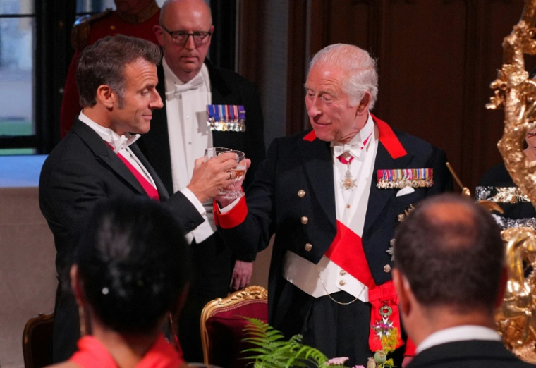 Le président français Emmanuel Macron (g) et le roi Charles III trinquent lors d'un dîner d'Etat au château de Windsor, à l'ouest de Londres, le 8 juillet 2025 ( POOL / Yui Mok )