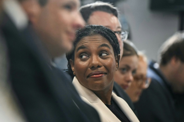 La cheffe du Parti conservateur, Kemi Badenoch (au centre), écoute une conférence de presse dans le centre de Londres, le 19 août 2026 ( AFP / JUSTIN TALLIS )
