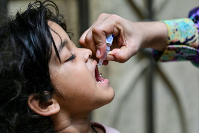 Un agent de santé administre des gouttes anti-polio à un enfant pour le vacciner à Karachi, au Pakistan, le 26 mai 2025 ( AFP / Asif HASSAN )