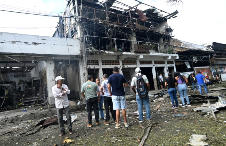 Des passants devant les dégâts provoqués par l'explosion d'une voiture piégée à Corinto, en Colombie, le 10 juin 2025 ( AFP / JOAQUIN SARMIENTO )