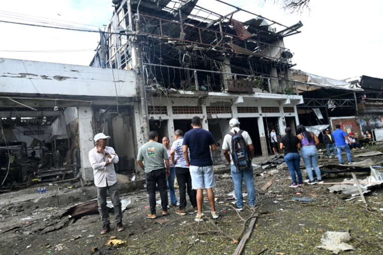 Des passants devant les dégâts provoqués par l'explosion d'une voiture piégée à Corinto, en Colombie, le 10 juin 2025 ( AFP / JOAQUIN SARMIENTO )