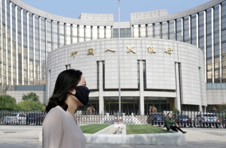 Une femme passe devant le siège de la Banque populaire de Chine (PBOC), la banque centrale, à Pékin