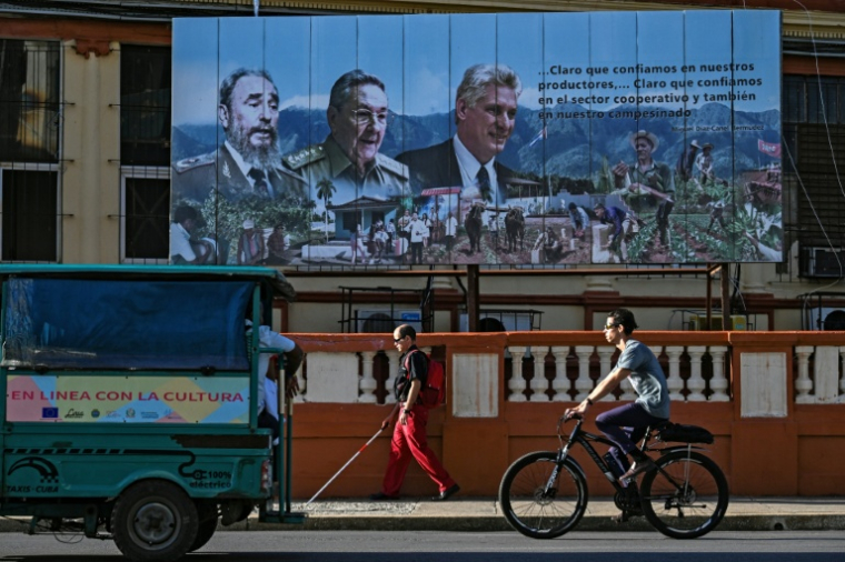 Une affiche dans une rue de La Havane montre Fidel Castro, son frère Raul Castro et le président cubain Miguel Diaz-Canel, le 20 mai 2026 ( AFP / YAMIL LAGE )