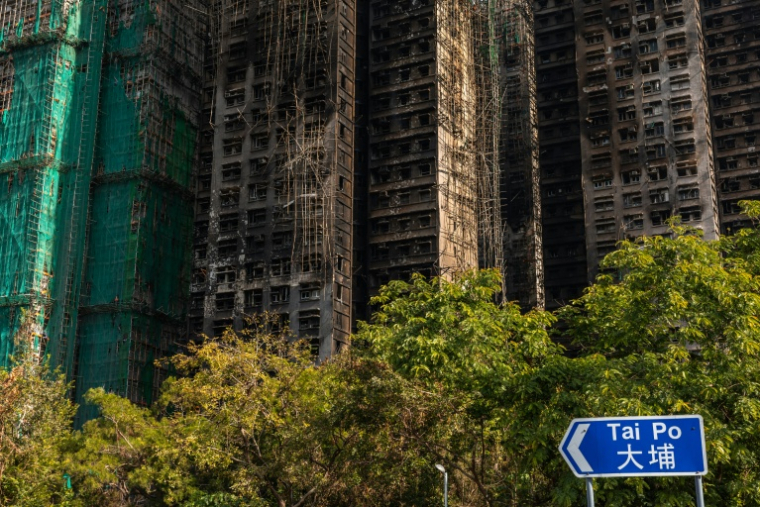 Des échafaudages en bambou et des filets de protection sur les façades des tours calcinées du complexe résidentiel Wang Fuk Court, après un incendie, le 28 novembre 2025 à Hong Kong ( AFP / Dale DE LA REY )