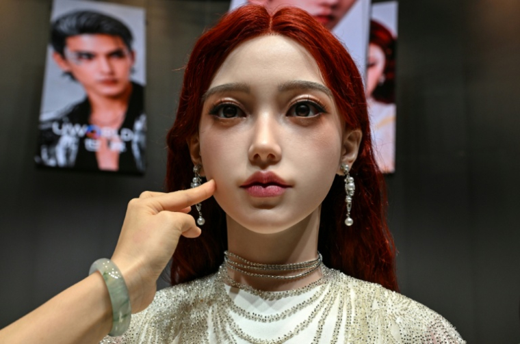 Une femme touche la peau d'un robot androïde U1 présenté à Shenzen, le 30 juin 2026 dans la province chinoise du Guangdong ( AFP / ADEK BERRY )