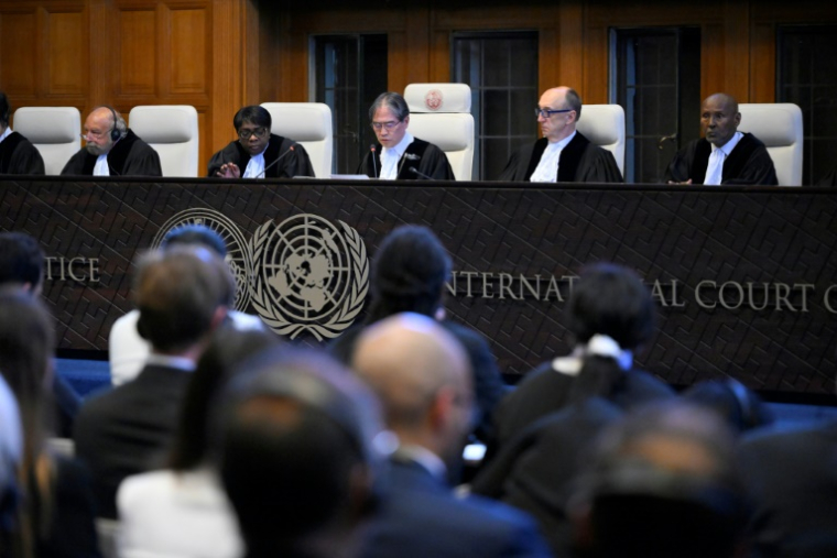 Le président de la Cour de justice internationale Yuji Iwasawa (C) présente la premier avis consultatif de l'institution sur les obligations légales des pays face au changement climatique, le 25 juillet 2025 à La Haye ( AFP / JOHN THYS )