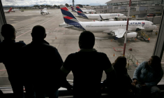 Des passagers vénézuéliens regardent des avions de la compagnie LATAM après l'annulation de leur vol pour Caracas, le 19 mai 2025 à l'aéroport El Dorado de Bogota ( AFP / Raul ARBOLEDA )