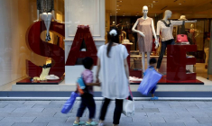 Une femme et ses enfants passent devant la vitrine d'un magasin de marques de luxe à Tokyo