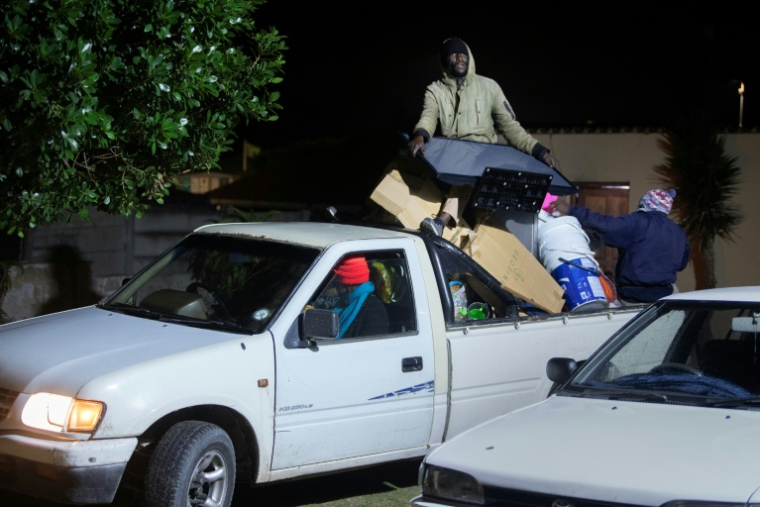 Des étrangers avec leurs effets personnels se réfugient dans une salle communautaire à Gansbaai, à environ 140 km du Cap (Afrique du Sud), le 2 juin 2026, après avoir été menacés par des groupes anti-migrants. ( AFP / RODGER BOSCH )