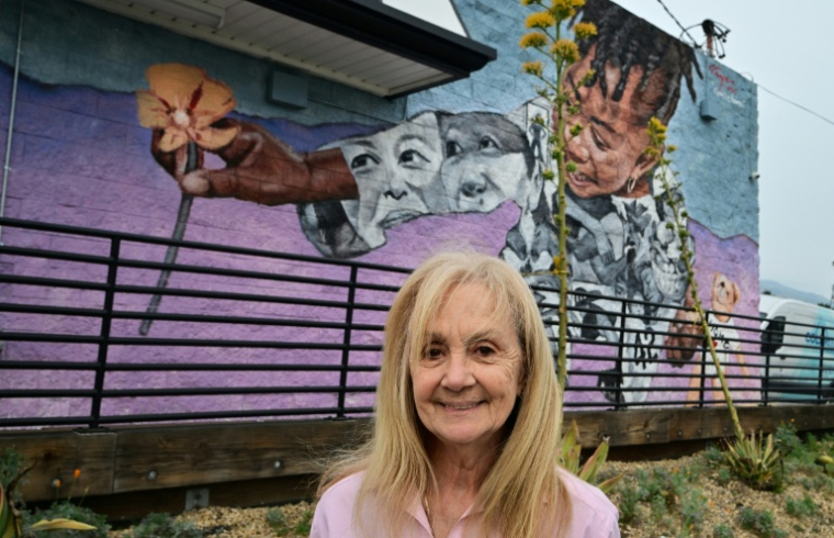 Roxanne Albee, une habitante d'Altadena, devant un fast-food décoré d'une fresque murale en hommage aux pavots de Californie, le 30 mars 2026 ( AFP / Frederic J. BROWN )