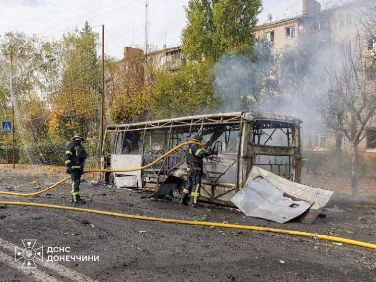 Photo diffusée par le Service d'État ukrainien pour les situations d'urgence le 8 octobre 2026 montrant des pompiers sur le site où deux bus ont été touchés par une frappe russe à Kramatorsk, près de la ligne de front, dans l'est de l'Ukraine ( Ukrainian State Emergency Service / Handout )