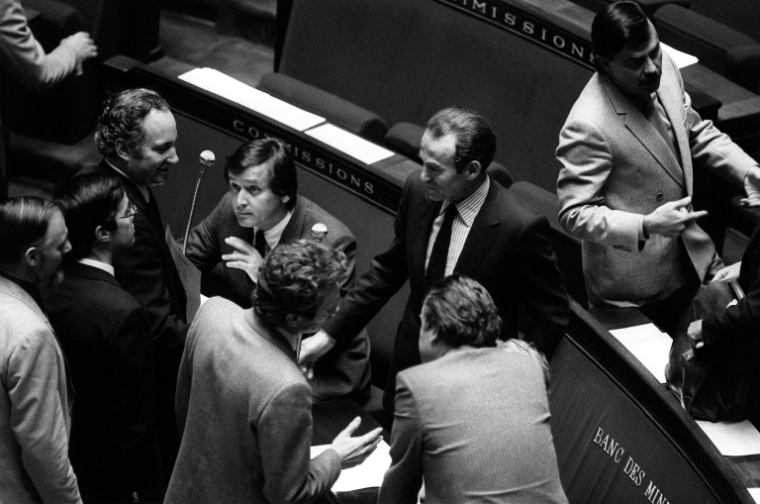 Des députés félicitent le ministre de la Justice Robert Badinter (c) dans l'hémicycle de l'Assemblée nationale après l'examen de son projet de loi sur l'abolition de la peine de mort, le 17 septembre 1981 à Paris ( AFP / DOMINIQUE FAGET )