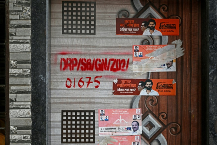 Une marque rouge sur la porte d'une maison dans le cadre d'un projet de rénovation urbaine du bidonville de Dharavi, le 8 juillet 2025 à Bombay, en Inde ( AFP / Indranil MUKHERJEE )