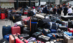 Des bagages empilés devant l'entrée du terminal d'Orly 4, après un incident technique à Paris-Orly, le 3 août 2023. ( AFP / STEFANO RELLANDINI )