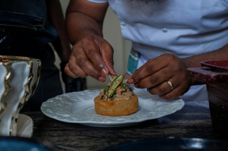 Le chef congolais Archi Dimosi dresse l'une de ses spécialités, le 17 mai 2026 à Kinshasa, en RDC ( AFP / Hardy BOPE )