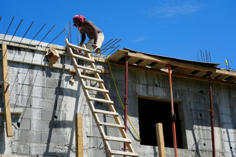 Un ouvrier reconstruit le toit d'une maison à Mamoudzou, un an après le passage du cyclone Chido à Mayotte, le 4 décembre 2025 ( AFP / Marine GACHET )