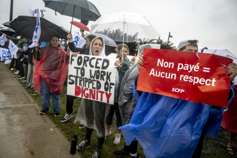 Des hôtesses et stewards manifestent devant l'aéroport Pierre-Elliott Trudeau à Montréal, au Québec, le 17 août 2025 au Canada ( AFP / ANDREJ IVANOV )