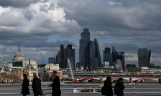 Des personnes traversent le pont de Waterloo avec les gratte-ciel du quartier financier de la City de Londres et la cathédrale Saint-Paul visibles en arrière-plan, à Londres