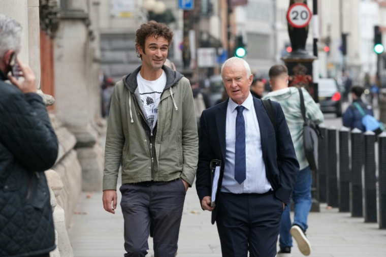 Adam Kamenetzky (g), l'un des plaignants, et l'avocat Martyn Day du cabinet Leigh Day, principal représentant des plaignants, arrivent à la Haute Cour à Londres, pour l'ouverture du procès de cinq géants de l'automobile impliqués dans le scandale des voitures diesel truquées, le 13 octobre 2025 ( AFP / CARLOS JASSO )