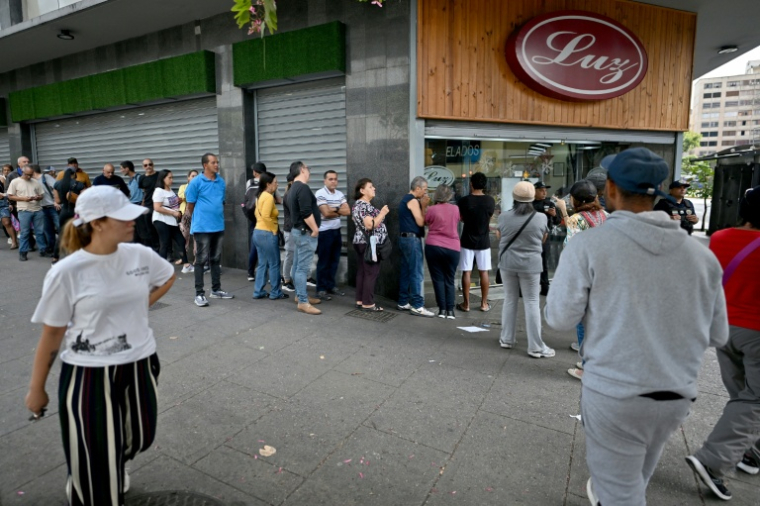 Des personnes font la queue devant un supermarché à Caracas le 3 janvier 2026, après que les forces américaines ont capturé le dirigeant vénézuélien Nicolás Maduro ( AFP / Juan BARRETO )
