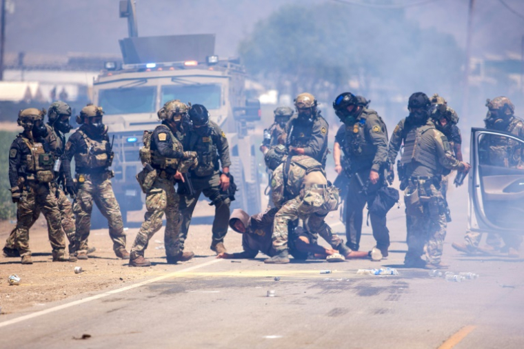 Des agents fédéraux arrêtent un homme lors d'une descente de la police de l'immigration dans une ferme de Camarillo, en Californie, le 10 juillet 2025 ( AFP / BLAKE FAGAN )