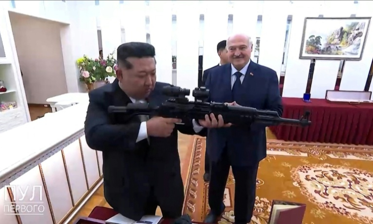 Image tirée d'une vidéo publiée sur le compte Telegram pul_1 et reçue via l'AFPTV, le 26 mars 2026, montrant le président biélorusse Alexandre Loukachenko (d) regardant le dirigeant nord-coréen Kim Jong Un tenir un fusil qui lui a été offert par Loukachenko à Pyongyang ( TELEGRAM/@pul_1 / - )