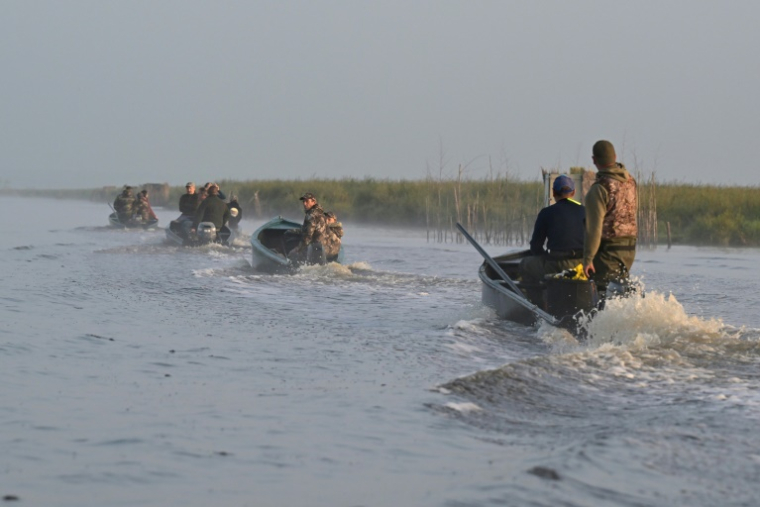 Des chasseurs patrouillent dans le marais de Brière à la recherche d'oiseaux victimes de l'épizootie de botulisme aviaire qui touche plusieurs zones humides de Loire-Atlantique, le 26 juillet 2025 près de Trignac ( AFP / Damien MEYER )