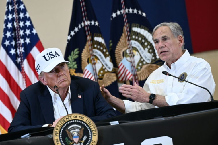 Le président américain Donald Trump et le gouverneur du Texas, Greg Abbott (d), lors d'une réunion avec des responsables locaux après des inondations meurtrières, le 11 juillet 2025 à Kerrville, au Texas ( AFP / Brendan SMIALOWSKI )