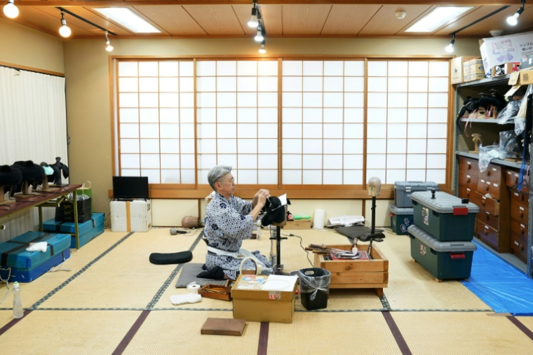 Le maître perruquier Tadashi Kamoji travaille sur une perruque pour les acteurs de kabuki dans son atelier à Tokyo, le 11 mars 2026 ( AFP / Kazuhiro NOGI )