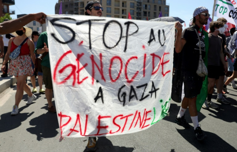 Des manifestants brandissent une pancarte lors d'un rassemblement contre "l'économie de guerre" et le "business de la mort", en direction du Salon du Bourget, à Bobigny (Seine-Saint-Denis), le 21 juin 2025 ( AFP / ROMAIN PERROCHEAU )