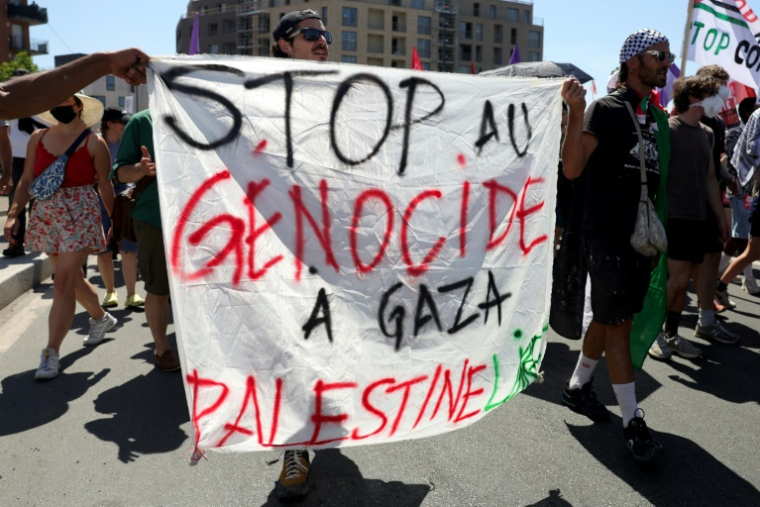 Des manifestants brandissent une pancarte lors d'un rassemblement contre "l'économie de guerre" et le "business de la mort", en direction du Salon du Bourget, à Bobigny (Seine-Saint-Denis), le 21 juin 2025 ( AFP / ROMAIN PERROCHEAU )