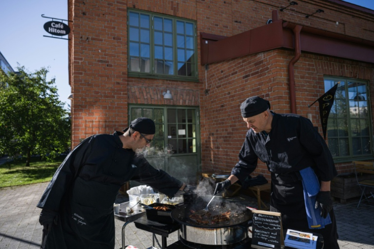 Préparation d'un plat au café Hitom à Hägersten, au sud de Stockholm, lors d'une initiative visant à sensibiliser aux repas qui peuvent être préparés dans des conditions d'état d'urgence, le 23 septembre 2025 en Suède ( AFP / Jonathan NACKSTRAND )