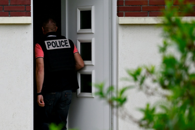 Un policier entre dans la maison où un père de famille s'est suicidé après avoir tiré sur ses deux enfants à Blénod-lès-Pont-à-Mousson, le 11 mai 2026 ( AFP / Jean-Christophe VERHAEGEN )