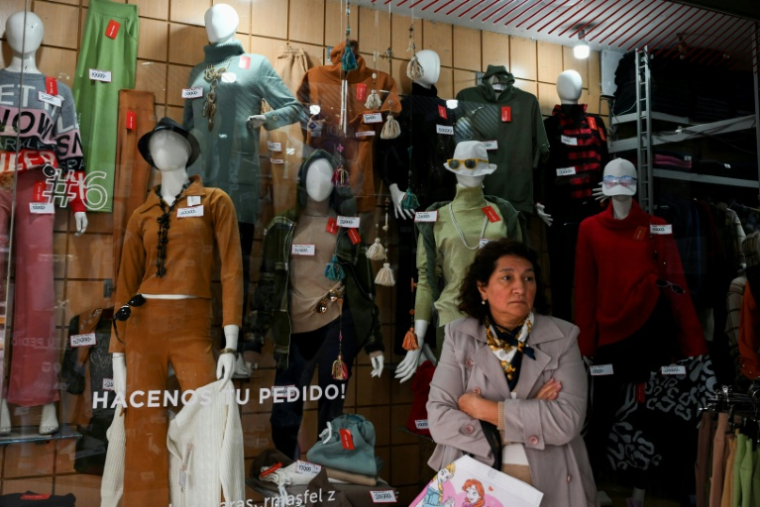 Une femme devant la vitrine d'un magasin de vêtements à Buenos Aires, le 14 juillet 2025 en Argentine ( AFP / Luis ROBAYO )
