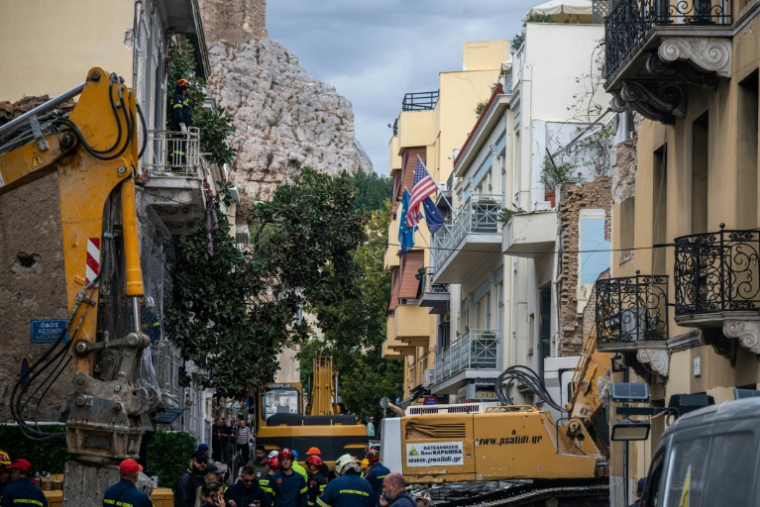 Des secouristes dans le centre historique d'Athènes après l'effondrement d'un immeuble qui a fait six morts, le 26 septembre 2026  ( AFP / Angelos TZORTZINIS )