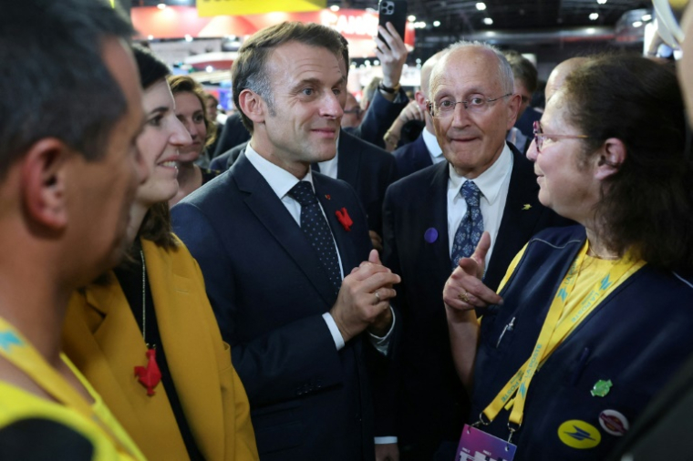 Le président français Emmanuel Macron se tient aux côtés du PDG du groupe La Poste, Philippe Wahl, et d'employés de La Poste au salon VivaTech, à Paris, le 11 juin 2025 ( POOL / Sarah Meyssonnier )