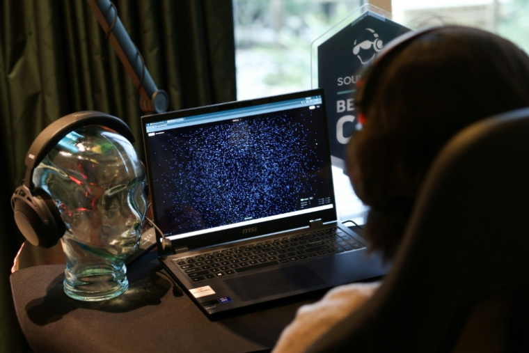 Ramses Alcaide, patron de la start-up Neurable, fait la démonstration de l'interface cerveau-ordinateur HyperX, et d'un casque audio de jeu permettant de mesurer l'activité des ondes cérébrales (EEG) et d'améliorer les fonctions cérébrales, lors du Consumer Electronics Show (CES) à Las Vegas, le 7 janvier 2026 au Nevada ( AFP / Patrick T. Fallon )