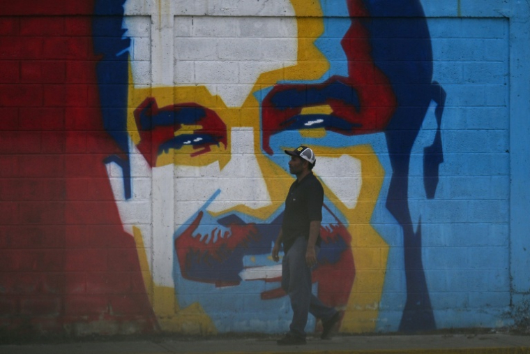 Un homme passe devant une fresque à l'effigie du président vénézuélien Nicolas Maduro, le 3 janvier 2026 ( AFP / Juan BARRETO )