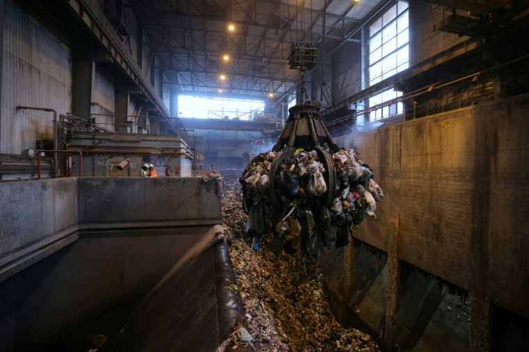Un grappin transporte des déchets ménagers d'une fosse à ordures vers le four de l'incinérateur Isséane Syctom, Issy-les-Moulineaux, le 25 novembre 2023 en périphérie de Paris ( AFP / Thomas SAMSON )