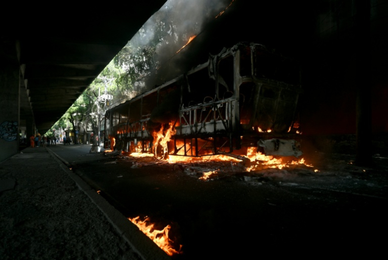 Un bus incendié vraisemblablement par des trafiquants de drogue, lors d'une opération de police à Rio de Janeiro, le 18 mars 2026 au Brésil ( AFP / Mauro PIMENTEL )