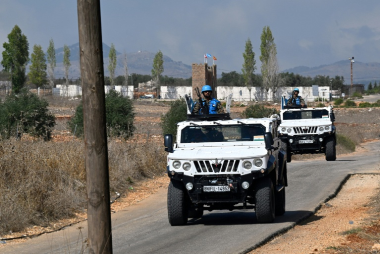 Un convoi de véhicules blindés du contingent indien de la Force intérimaire des Nations unies au Liban (Finul) passe devant la base du contingent espagnol de la finul, dans le village d'Ibl al-Saqi,  près de la frontière du sud du Liban, le 13 octobre 2026 ( AFP / Joseph EID )