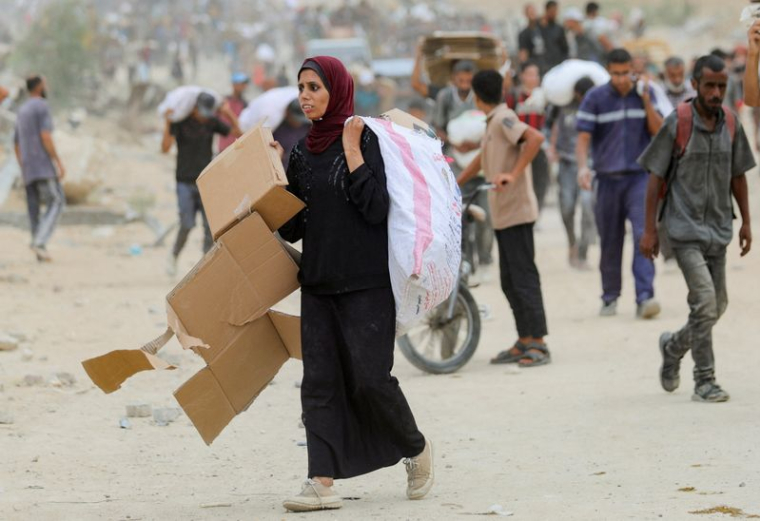 Des Palestiniens transportent des fournitures d'aide qu'ils ont reçues de la Fondation humanitaire de Gaza (GHF), soutenue par les États-Unis, dans le centre de la bande de Gaza.