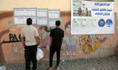 Des Irakiens déplacés consultent les listes nominatives affichées à l'extérieur d'un bureau de vote, à l'arrivée pour voter avant les élections législatives du 11 novembre, dans un camp du nord de l'Irak, le 9 novembre 2025 ( AFP / Safin HAMID )